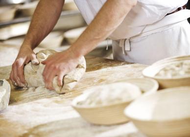 Boulanger qui pétrit de la pâte à pain